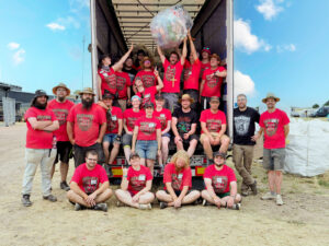 Gruppenbild der Helfer vor und auf einer LKW Ladefläche
